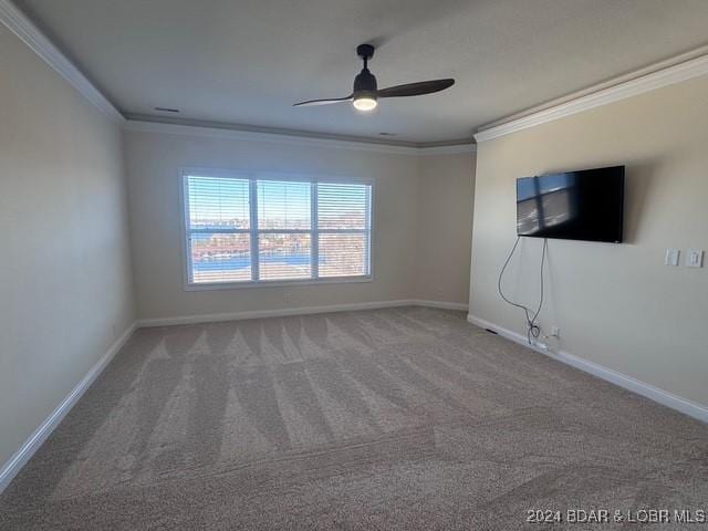 carpeted spare room featuring ceiling fan and ornamental molding