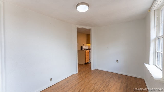 unfurnished room with baseboards and light wood finished floors