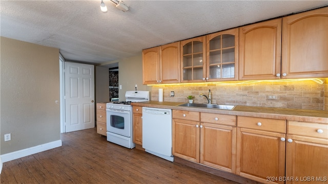 kitchen featuring white appliances, a sink, baseboards, dark wood-style floors, and tasteful backsplash