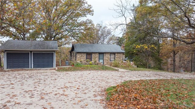 view of front facade featuring stone siding and a detached garage