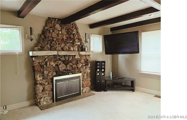 living room with a stone fireplace, carpet, beam ceiling, and baseboards