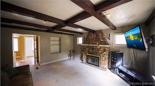 unfurnished living room featuring a fireplace, beam ceiling, and carpet floors