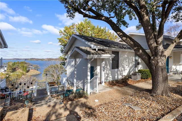 view of property exterior with central AC unit and a water view