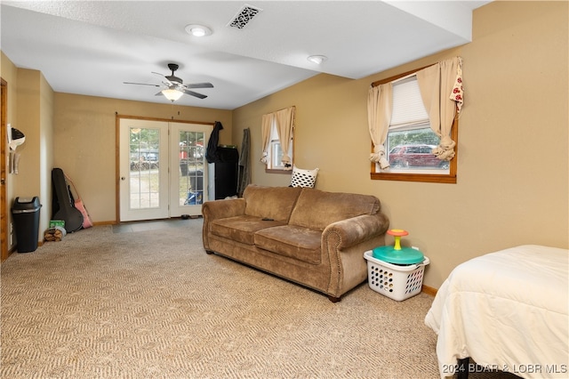 living room with ceiling fan, a healthy amount of sunlight, and light colored carpet