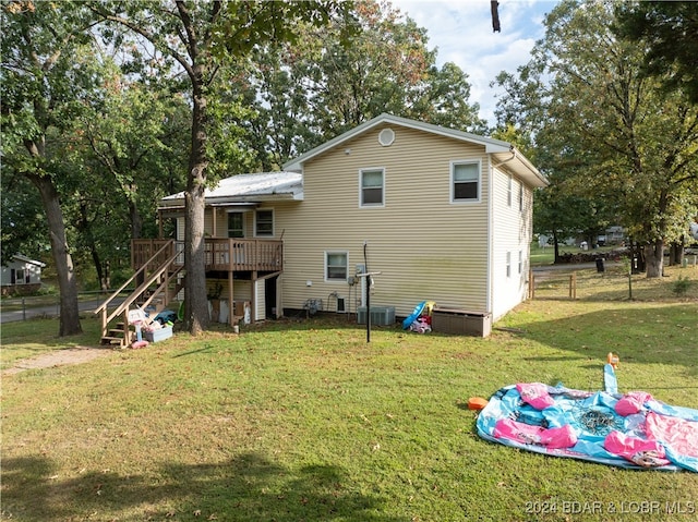 back of house featuring central AC, a yard, and a wooden deck