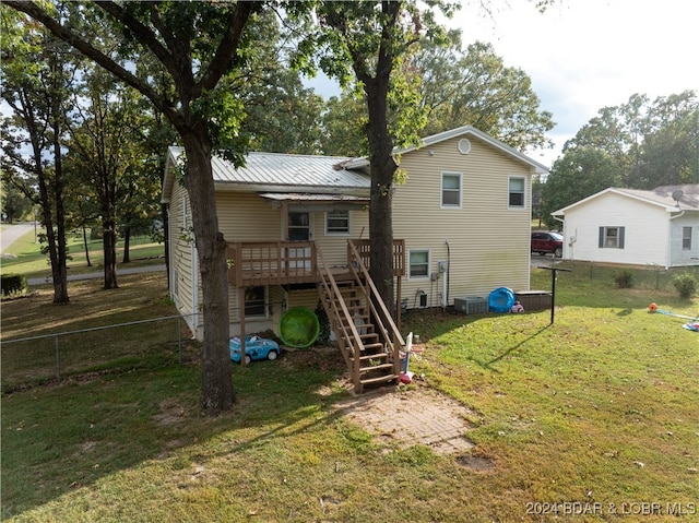 back of house with a deck, central air condition unit, and a lawn