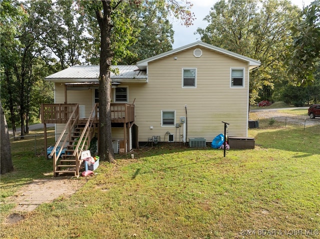 rear view of house featuring central air condition unit, a yard, and a wooden deck