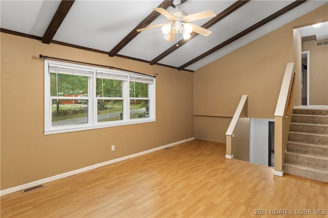 empty room with ceiling fan, vaulted ceiling with beams, and light hardwood / wood-style flooring