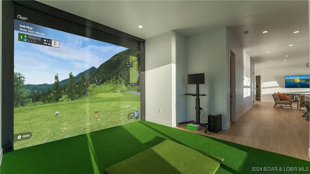 rec room with golf simulator, hardwood / wood-style flooring, and a mountain view