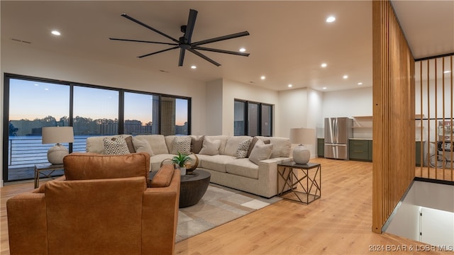 living room with light wood-type flooring and ceiling fan