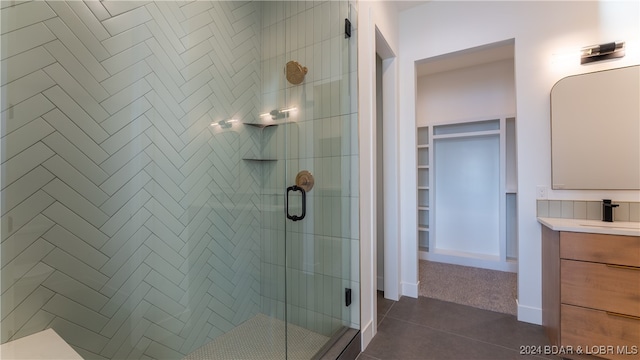 bathroom featuring walk in shower, tile patterned flooring, and vanity