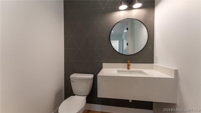 bathroom with tile walls, sink, and toilet