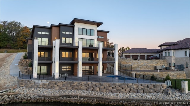 back house at dusk featuring a balcony