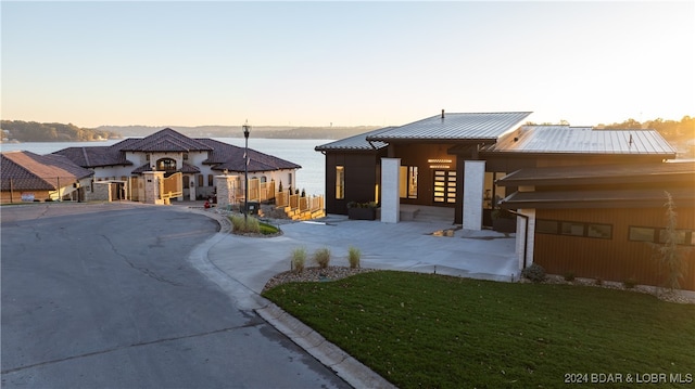 view of front of house with a yard and a water view