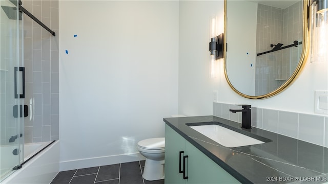 full bathroom featuring toilet, vanity, tile patterned flooring, and shower / bath combination with glass door