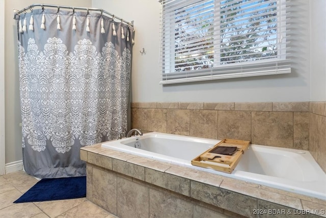 bathroom featuring tile patterned flooring and a relaxing tiled tub