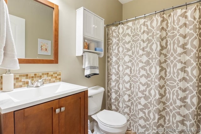 bathroom with vanity, toilet, and backsplash