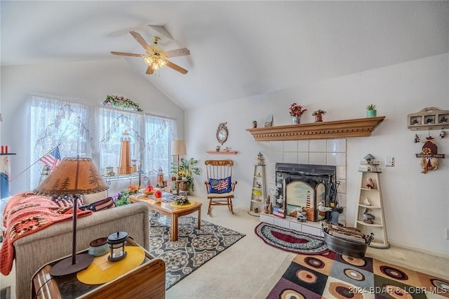 carpeted living room with lofted ceiling, a tiled fireplace, and a ceiling fan