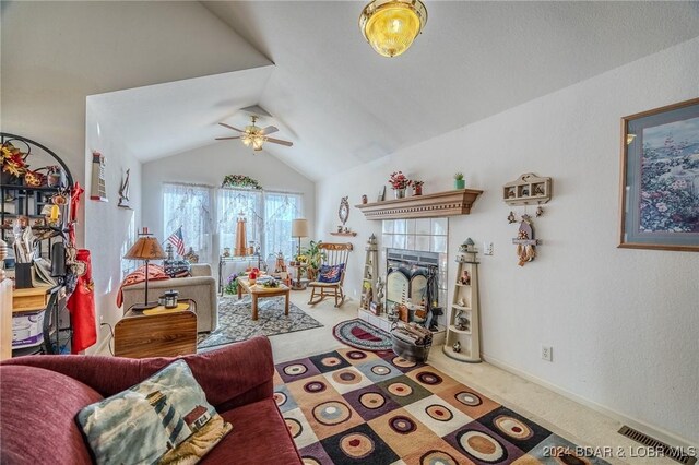 living room with lofted ceiling, ceiling fan, carpet, and a tile fireplace