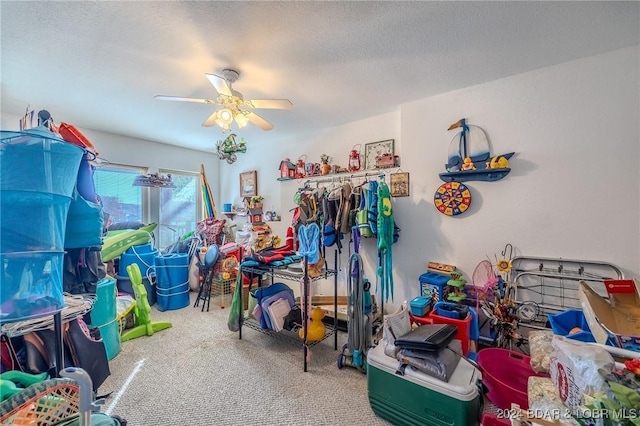 playroom featuring a textured ceiling, ceiling fan, and carpet flooring