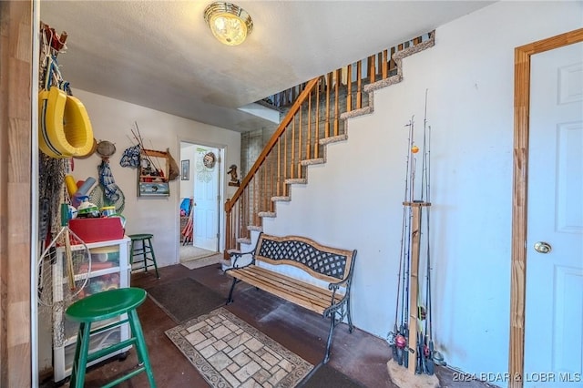 foyer with stairs and unfinished concrete floors