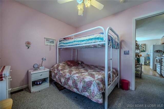 bedroom featuring light carpet, ceiling fan, and refrigerator