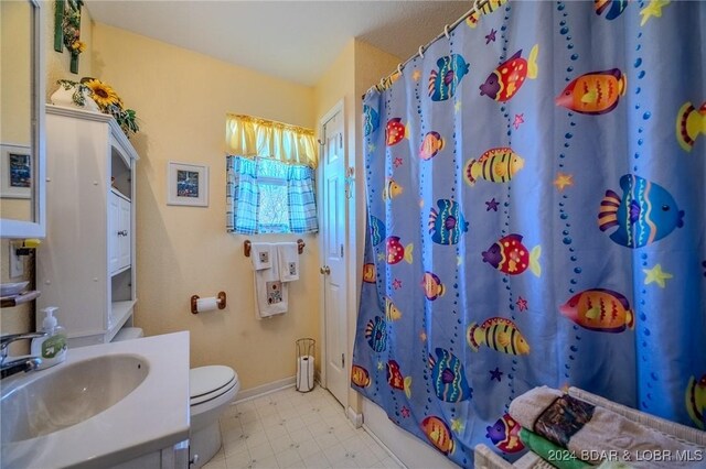 full bathroom with shower / bath combo with shower curtain, toilet, and vanity