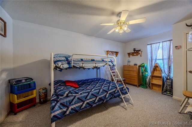 carpeted bedroom with ceiling fan and a textured ceiling