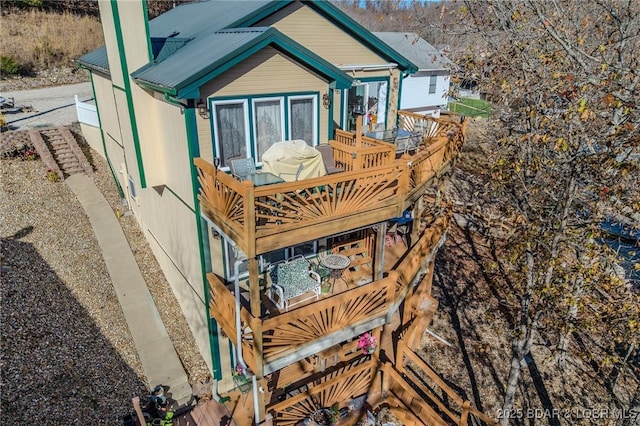 rear view of property featuring metal roof and a deck