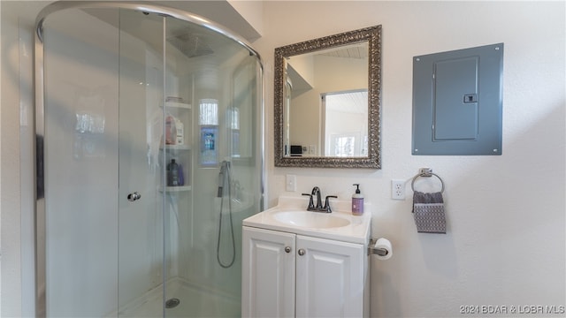 bathroom with electric panel, vanity, and a shower with shower door