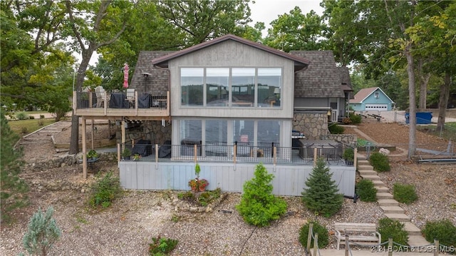 rear view of house featuring a wooden deck