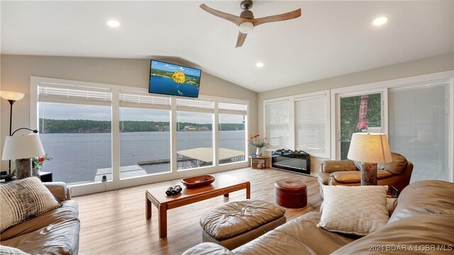 living room with ceiling fan, lofted ceiling, and light hardwood / wood-style floors