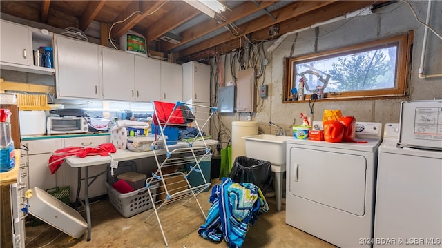 basement featuring washing machine and clothes dryer and electric panel