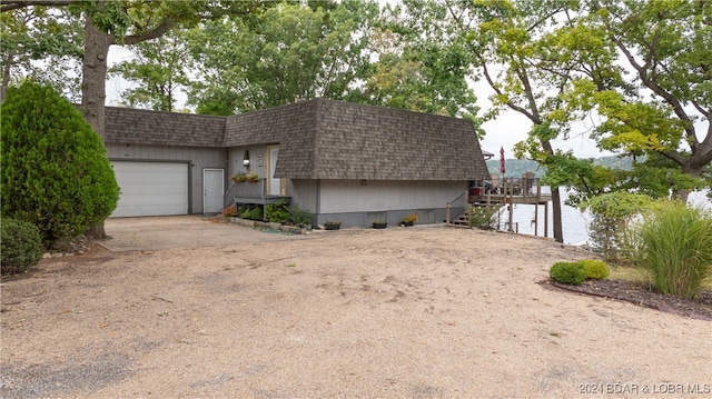 view of front of property with a garage and a water view