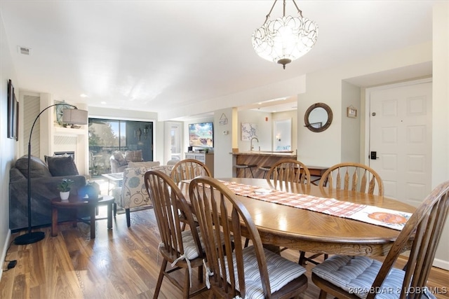 dining area featuring hardwood / wood-style flooring, a chandelier, and sink