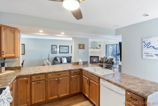 kitchen featuring kitchen peninsula, sink, white dishwasher, and light hardwood / wood-style flooring