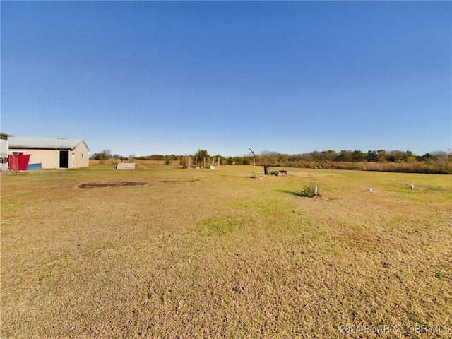 view of grassy yard featuring a view of rural / pastoral area