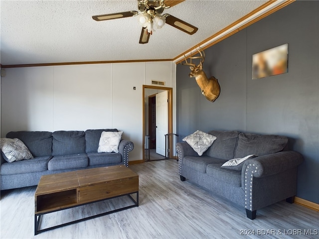 living room with hardwood / wood-style floors, ornamental molding, a textured ceiling, and vaulted ceiling