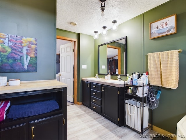 bathroom featuring vanity, wood-type flooring, and a textured ceiling