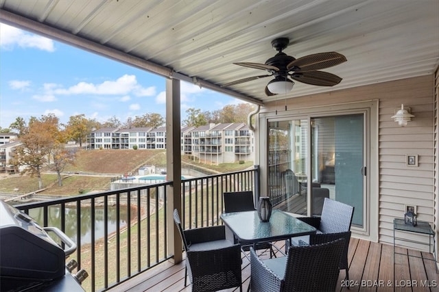 deck with a water view and ceiling fan