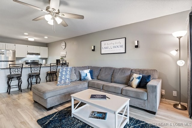 living room featuring light wood-type flooring and ceiling fan