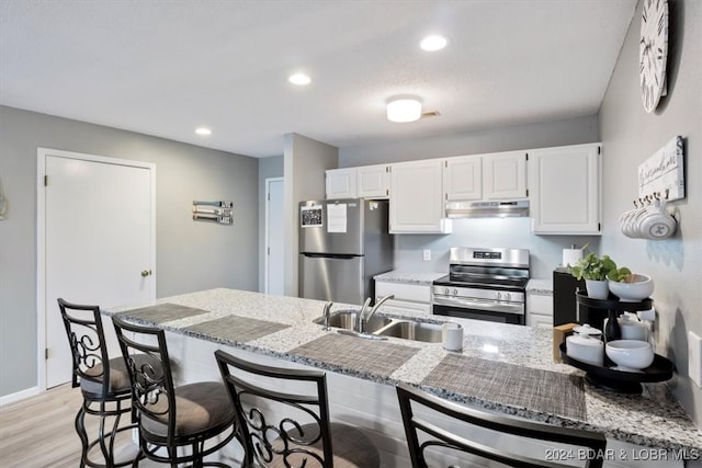 kitchen featuring white cabinetry, appliances with stainless steel finishes, sink, and light hardwood / wood-style flooring