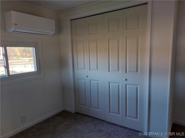 unfurnished bedroom with a closet, a wall mounted AC, and carpet floors