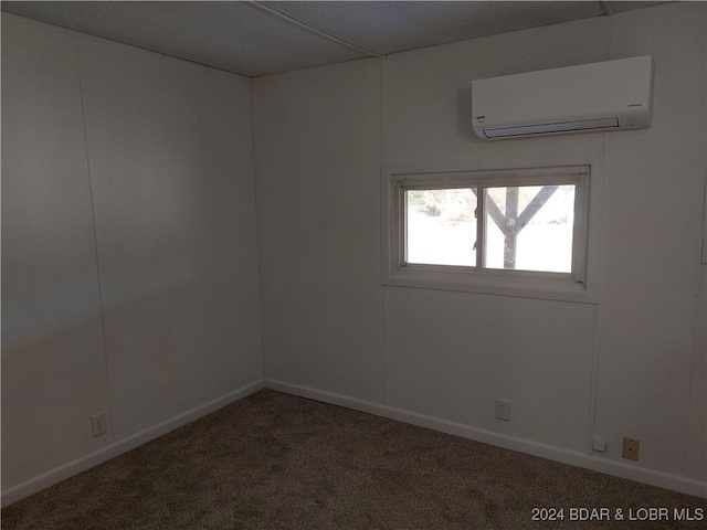 spare room with an AC wall unit and carpet floors