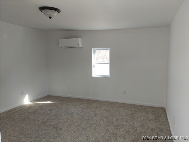 carpeted empty room featuring a wall unit AC