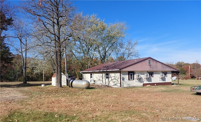 view of side of home featuring a storage unit and a yard