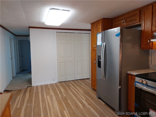 kitchen featuring appliances with stainless steel finishes, premium range hood, ornamental molding, and light hardwood / wood-style flooring