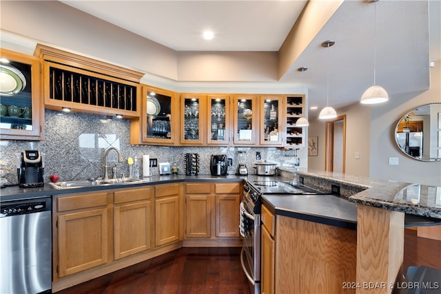 kitchen with sink, dark wood-type flooring, appliances with stainless steel finishes, backsplash, and decorative light fixtures