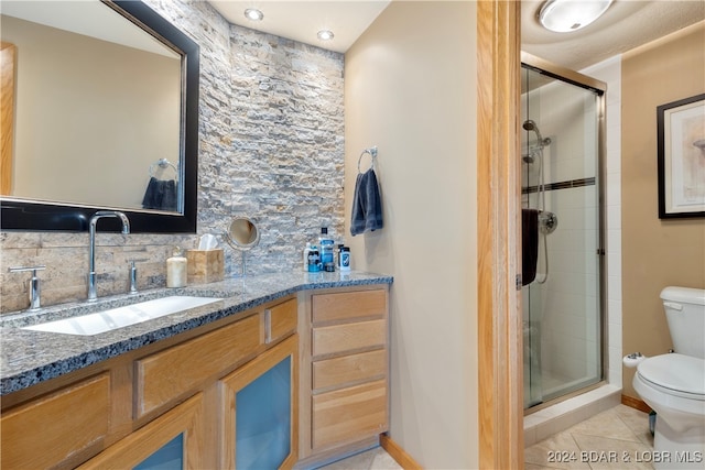 bathroom with a shower with door, tile patterned flooring, backsplash, and toilet