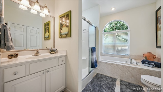 full bathroom with tile patterned flooring, vanity, shower with separate bathtub, and toilet